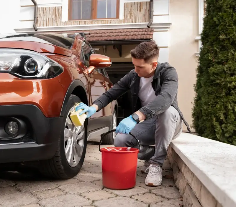 Lavage auto à domicile Vézelois : professionnel intervenant sur un véhicule